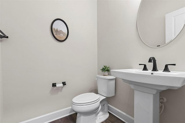 bathroom featuring wood-type flooring, toilet, and sink