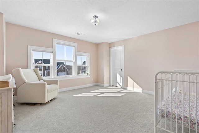 bedroom featuring a crib and light colored carpet