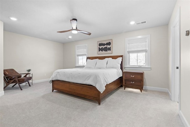 bedroom featuring light carpet, multiple windows, and ceiling fan