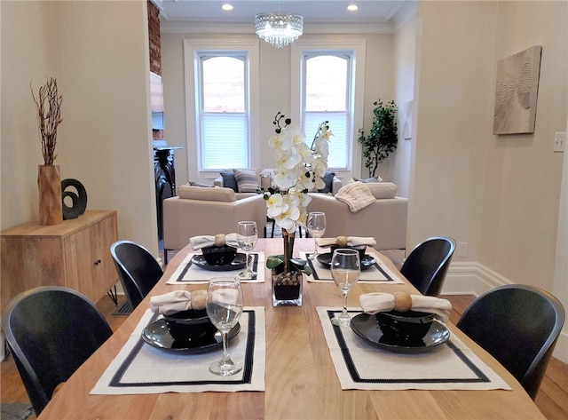 dining room with ornamental molding, hardwood / wood-style floors, and a notable chandelier