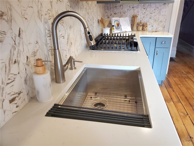 room details with sink, decorative backsplash, and blue cabinetry