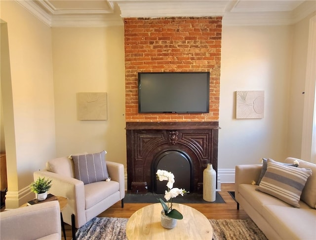 living room with hardwood / wood-style flooring, a large fireplace, and ornamental molding