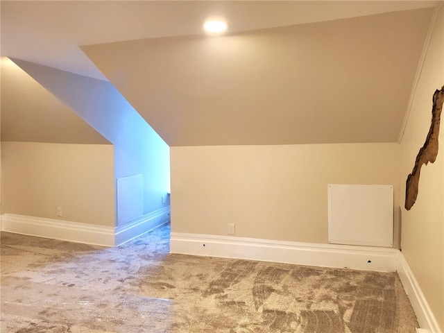 additional living space featuring carpet floors and vaulted ceiling