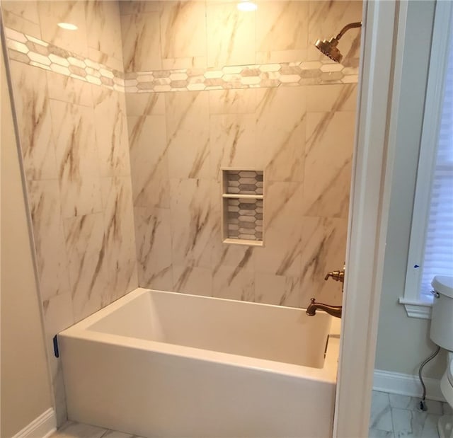 bathroom featuring tiled shower / bath and toilet