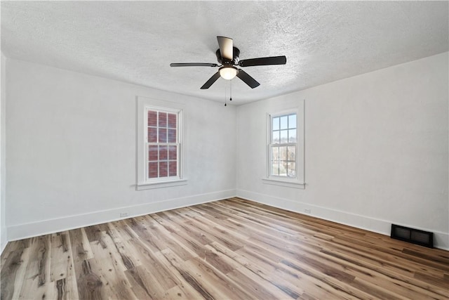 unfurnished room with a textured ceiling, light hardwood / wood-style floors, and ceiling fan