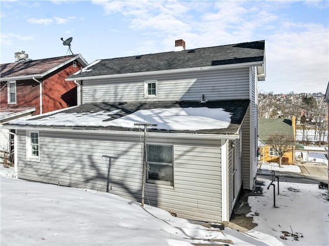 view of snow covered rear of property