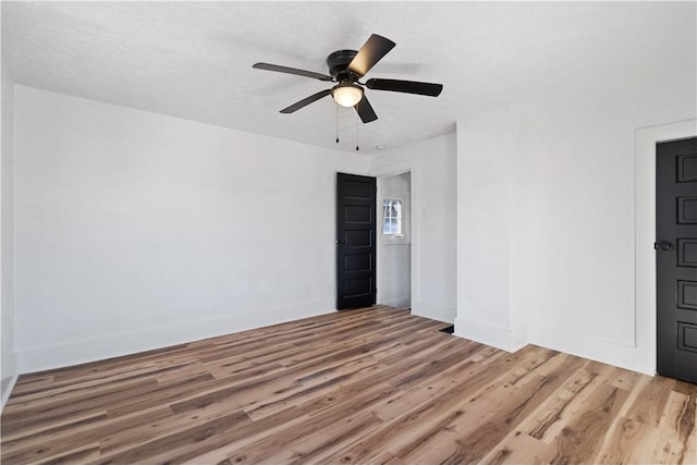 empty room featuring ceiling fan and hardwood / wood-style floors