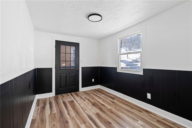 empty room with wood-type flooring and a textured ceiling