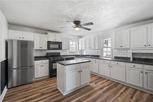 kitchen featuring white cabinets, a wealth of natural light, a center island, and black appliances