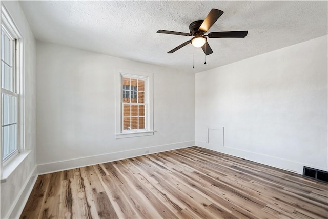 spare room featuring hardwood / wood-style flooring, ceiling fan, and a textured ceiling