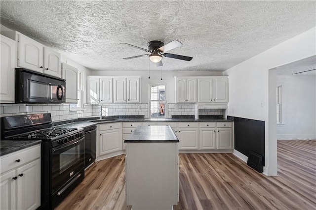 kitchen featuring white cabinetry, a center island, hardwood / wood-style floors, decorative backsplash, and black appliances