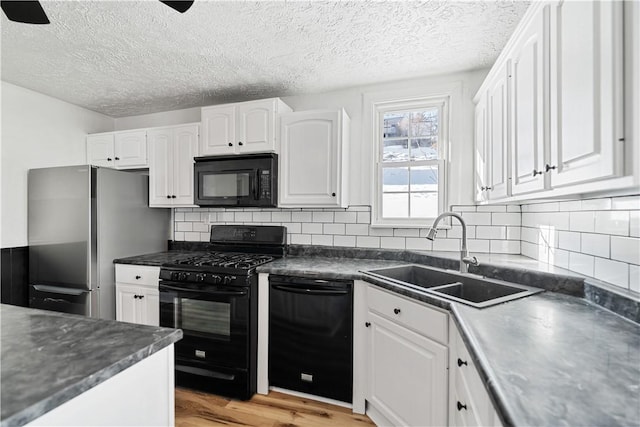 kitchen featuring sink, backsplash, black appliances, light hardwood / wood-style floors, and white cabinets