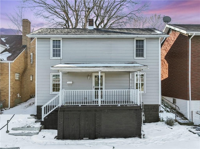 snow covered house with covered porch