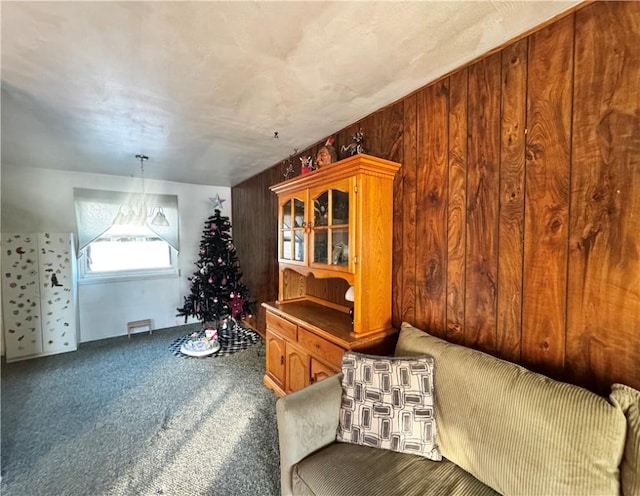 sitting room with carpet floors and wood walls