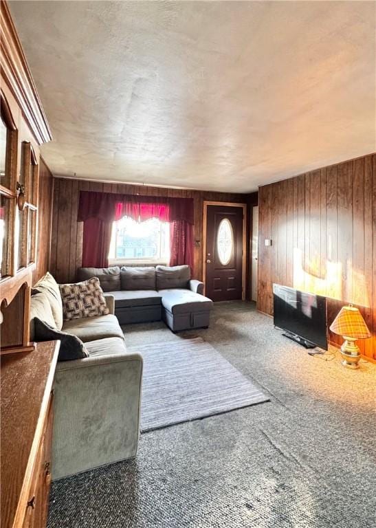 carpeted living room with wood walls