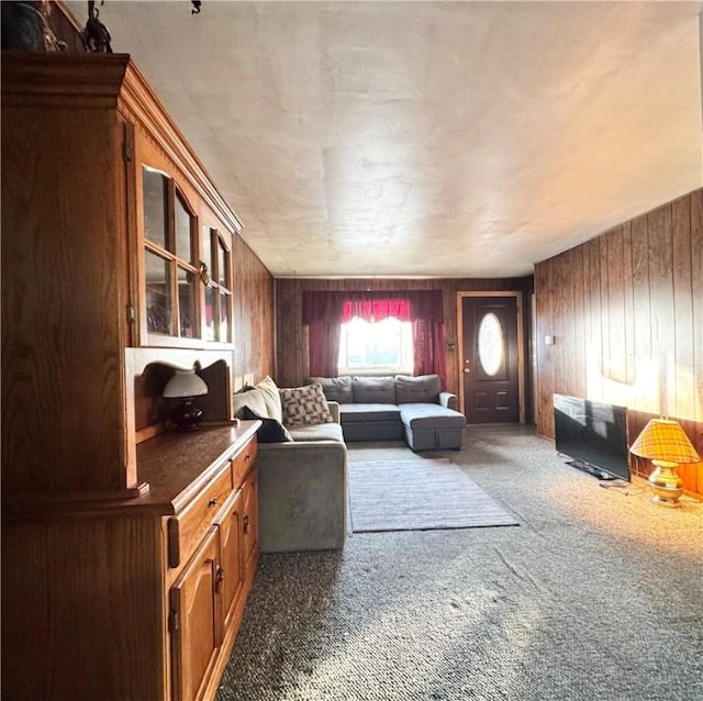 carpeted living room featuring wood walls