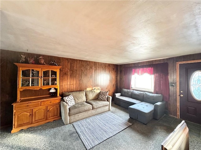 carpeted living room featuring wood walls