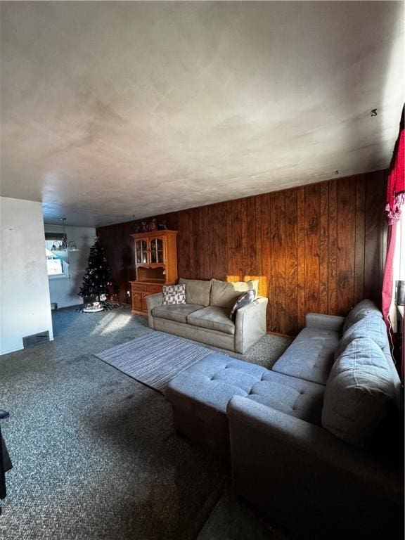 carpeted living room featuring wooden walls