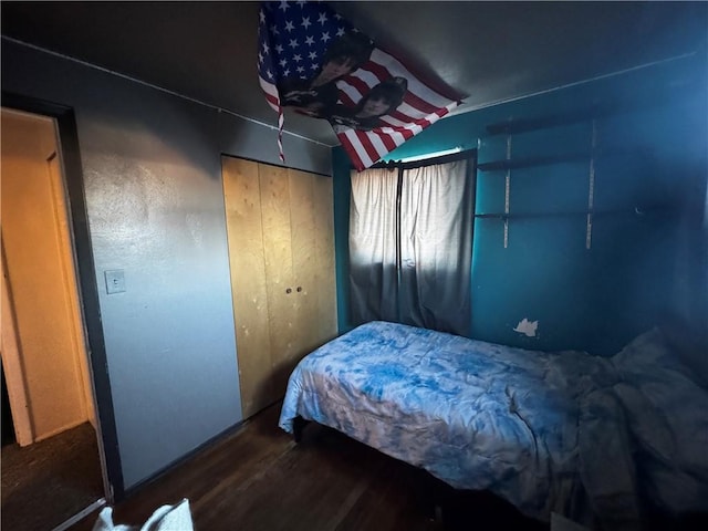 bedroom featuring lofted ceiling, dark wood-type flooring, and a closet