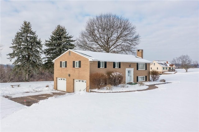 snow covered property with a garage