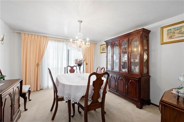 carpeted dining area with a chandelier