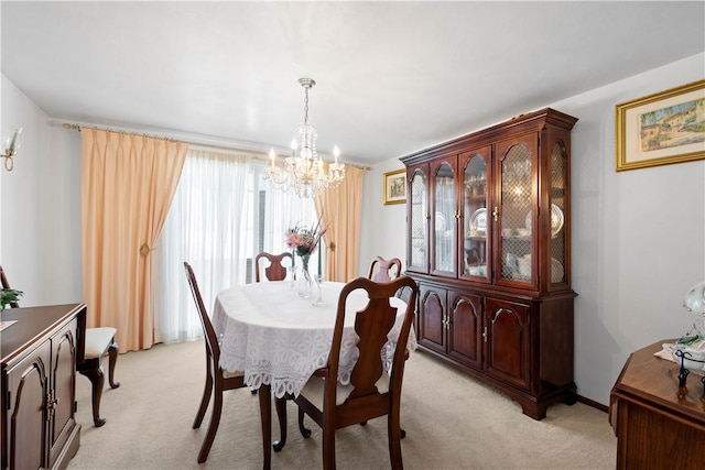 dining space featuring light colored carpet and a notable chandelier