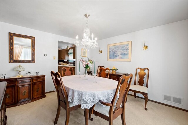 carpeted dining space featuring a notable chandelier