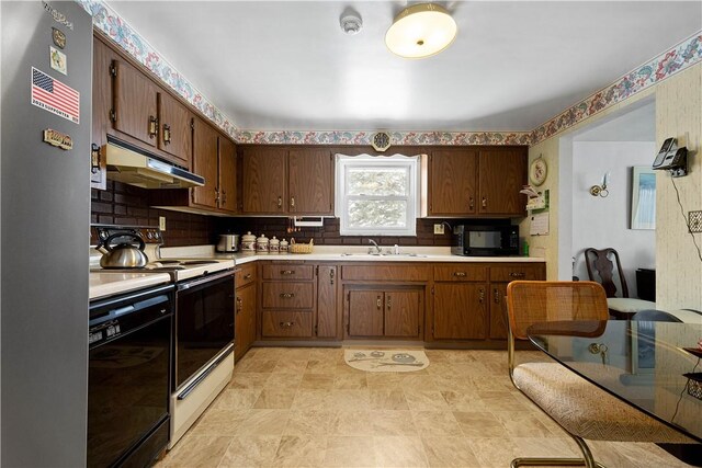 kitchen with dark brown cabinetry, sink, decorative backsplash, and black appliances