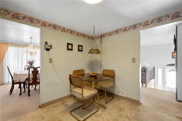 dining area with carpet floors and a notable chandelier