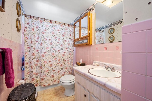 bathroom featuring a shower with curtain, vanity, tile walls, and toilet