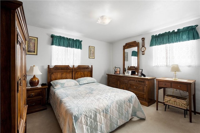 bedroom with light carpet and multiple windows