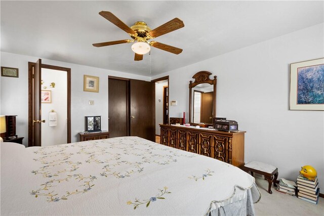 carpeted bedroom with ceiling fan and a closet