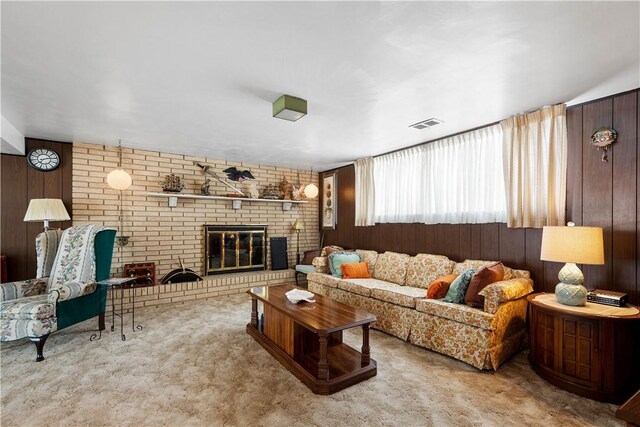 carpeted living room featuring wooden walls and a fireplace