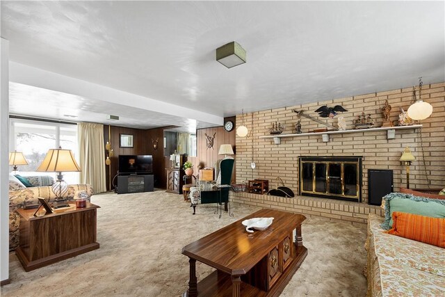 carpeted living room with wooden walls and a fireplace