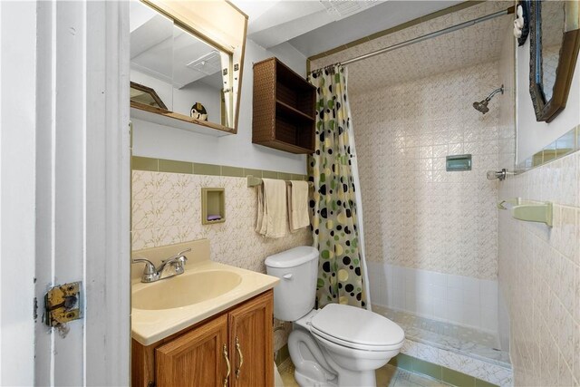 bathroom featuring vanity, toilet, tile walls, and walk in shower