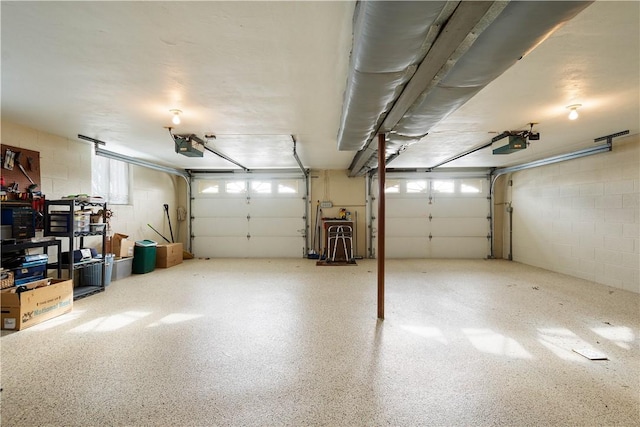 garage with concrete block wall and a garage door opener