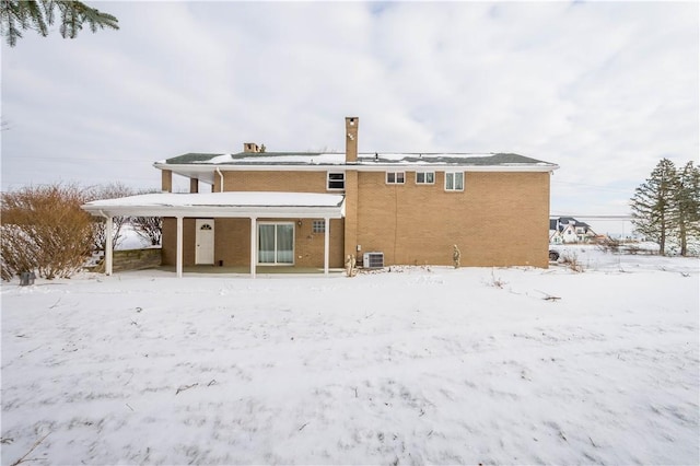 snow covered house with central AC unit