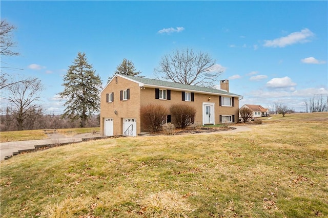 view of front of property featuring a garage, a front yard, driveway, and a chimney