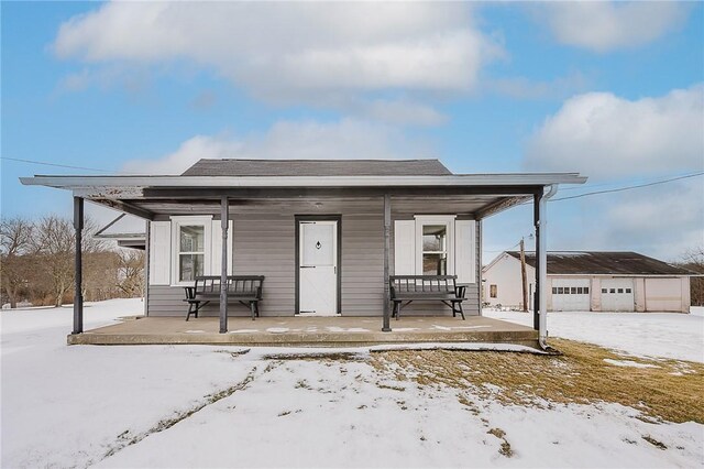 view of front of property featuring an outbuilding, a garage, and a porch