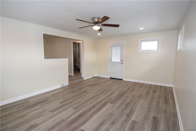 spare room with ceiling fan and light wood-type flooring