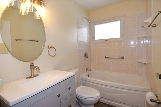 full bathroom with tiled shower / bath, vanity, and toilet