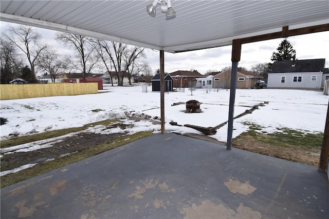 yard covered in snow with a storage shed