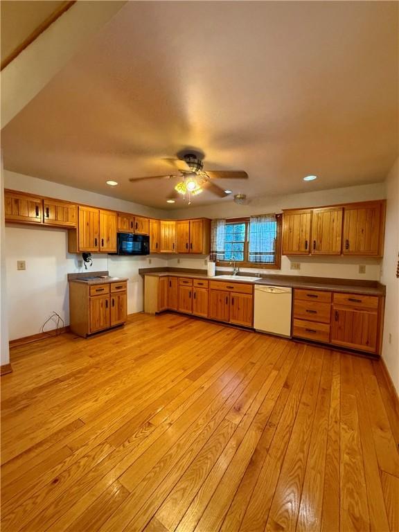 kitchen with ceiling fan, dishwasher, sink, and light wood-type flooring