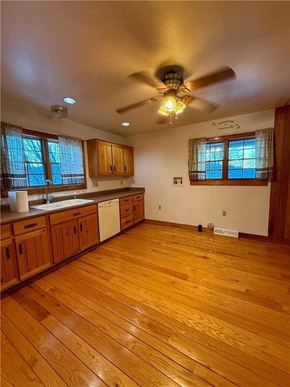 kitchen with white dishwasher, sink, light hardwood / wood-style flooring, and ceiling fan