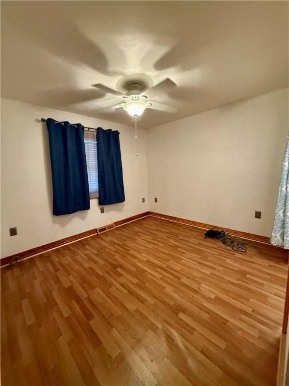 empty room featuring ceiling fan and hardwood / wood-style floors