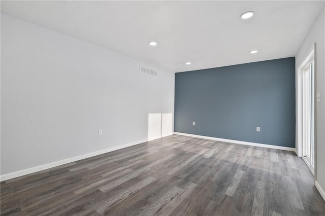 unfurnished room featuring a healthy amount of sunlight and dark hardwood / wood-style flooring