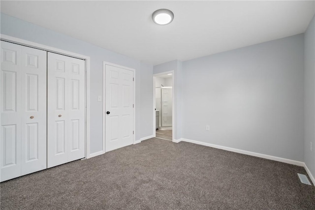 unfurnished bedroom featuring a closet and dark colored carpet