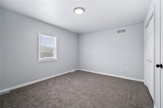 unfurnished bedroom with dark carpet