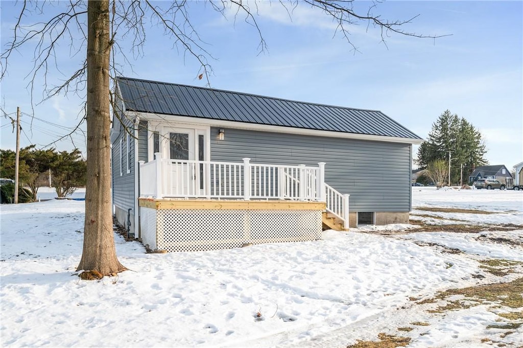 snow covered property with a wooden deck