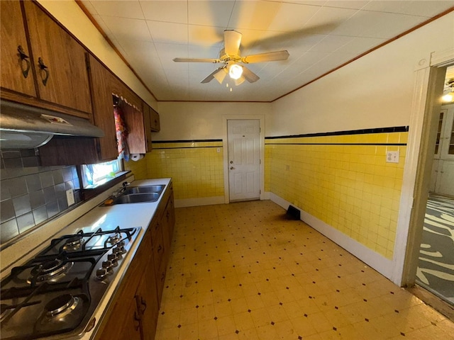 kitchen with tile walls, sink, gas cooktop, and ornamental molding